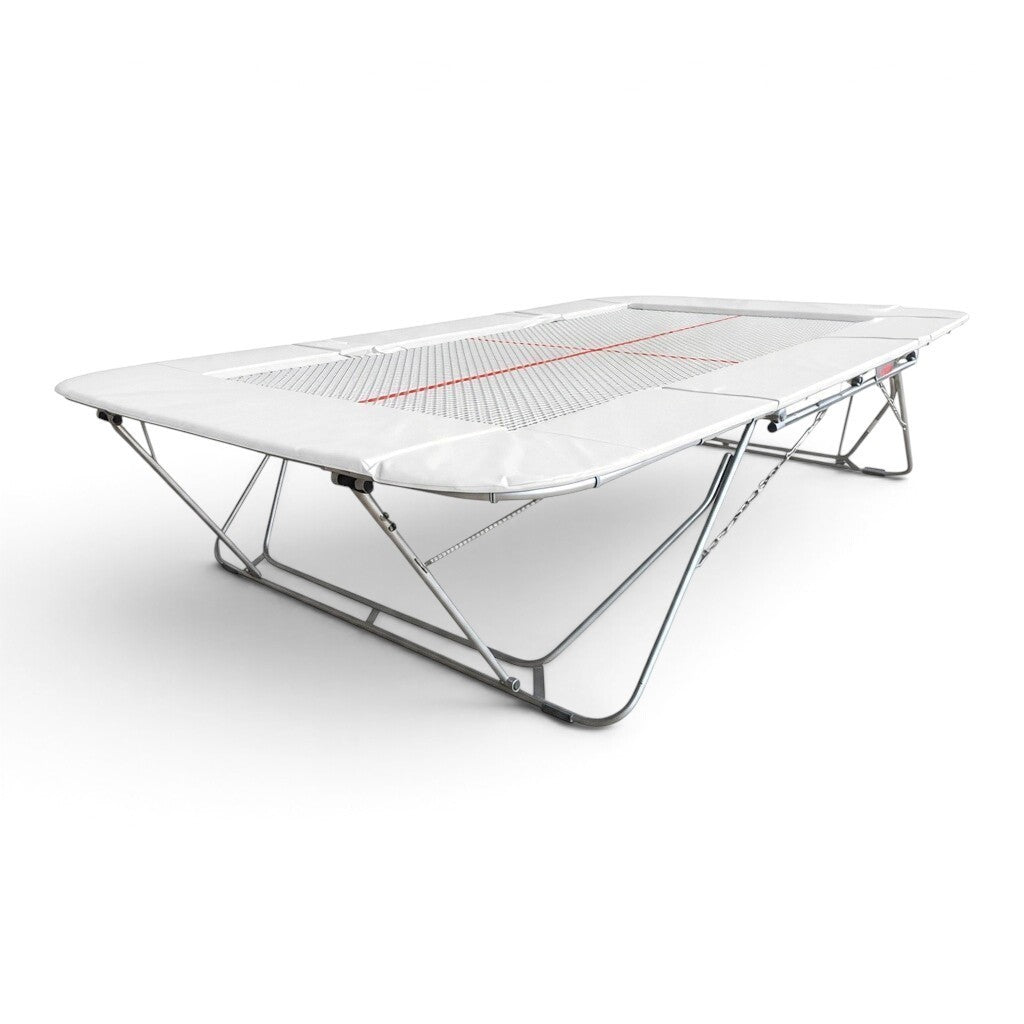 UK Gym Pits 77a standard competition trampoline with a 25mm web bed and white protective frame pads.