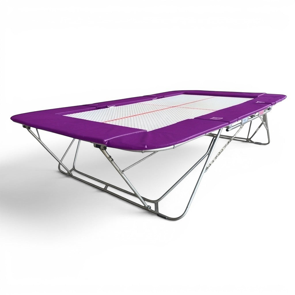UK Gym Pits 77a standard trampoline with a 25mm web bed and purple protective frame pads for gymnastics training.