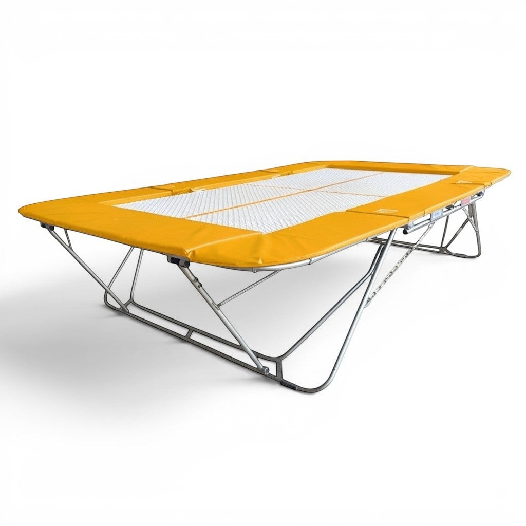 UK Gym Pits 77a standard trampoline with a 25mm web bed and yellow protective frame pads for gymnastics training.