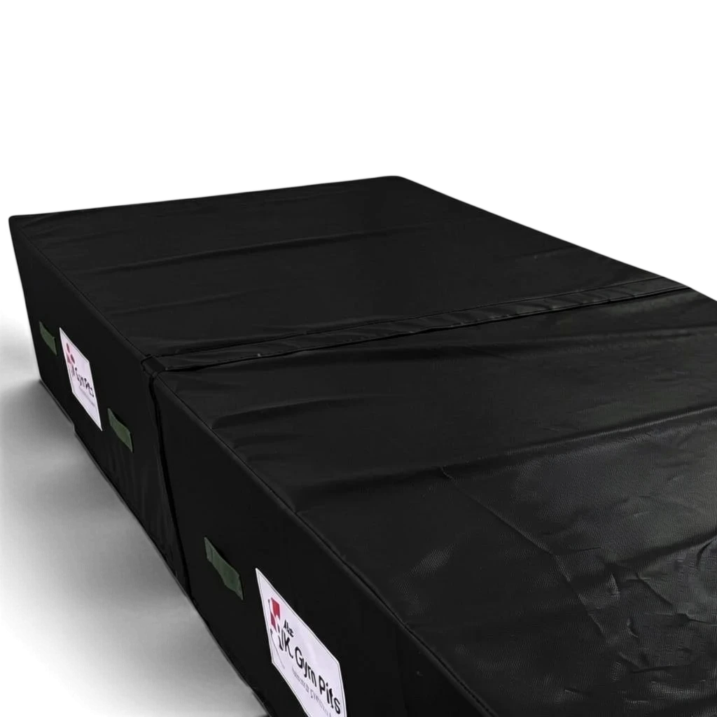 UK Gym Pits black heavy-duty foam track run-up block with reinforced PVC cover and side handles for gymnastics.