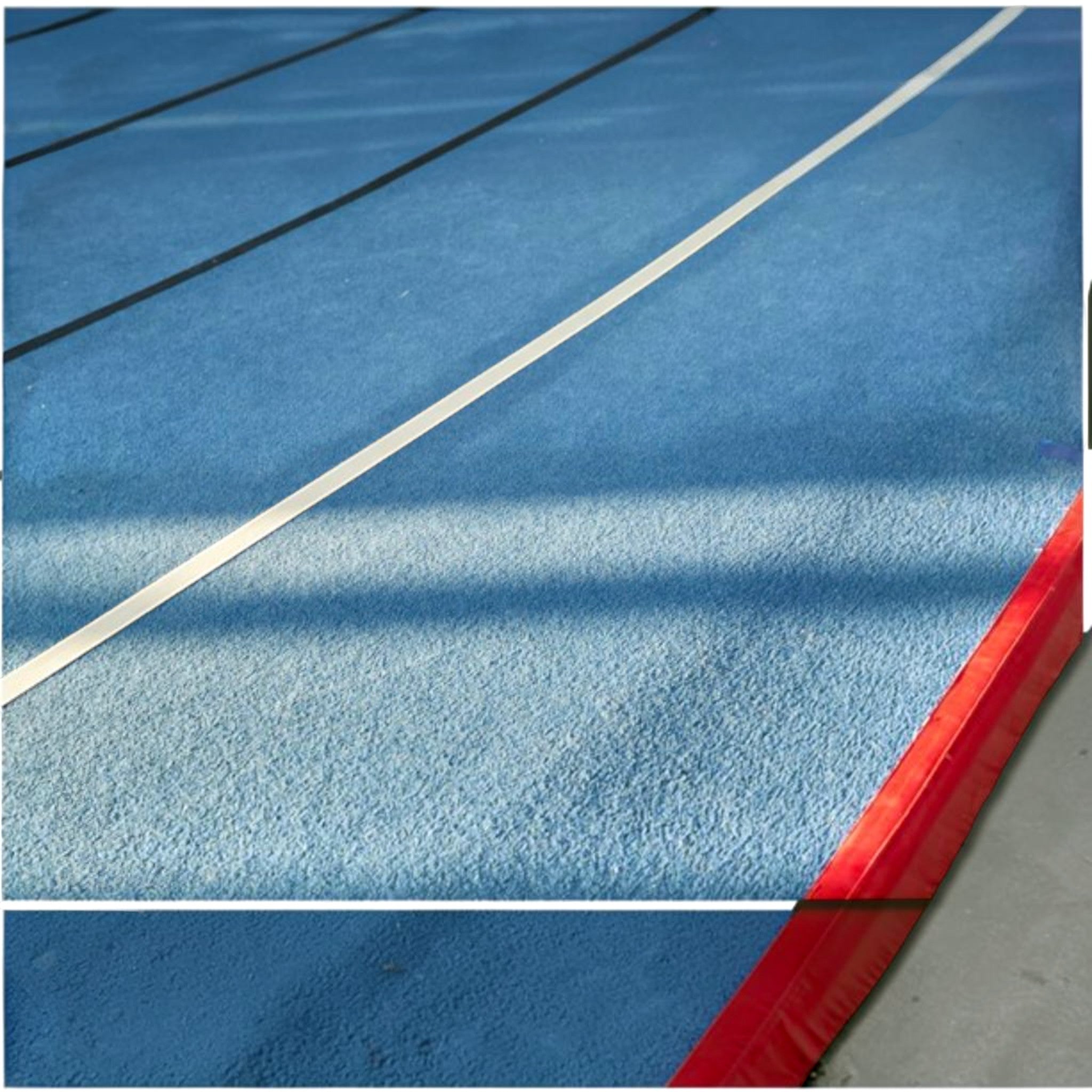 UK Gym Pits blue gymnastics sprung floor with white boundary lines and a red protective side skirt