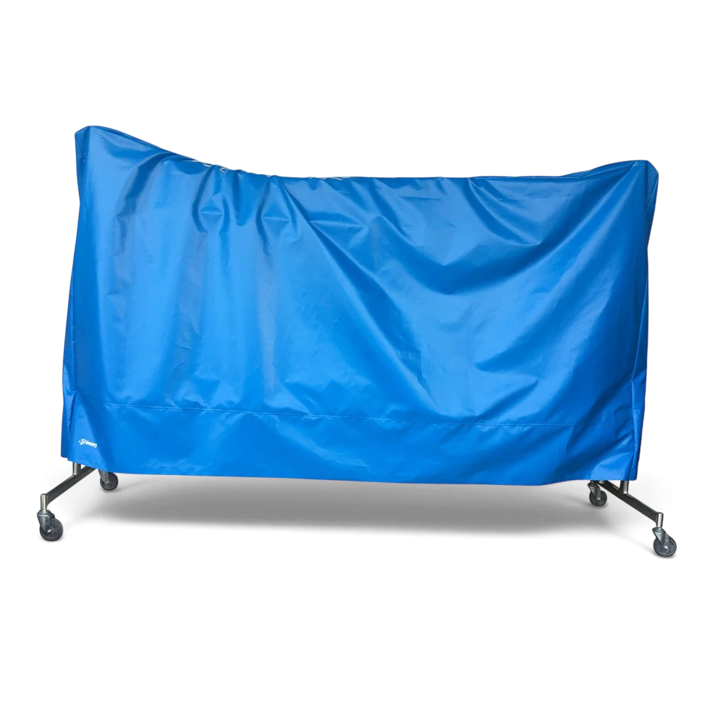 UK Gym Pits blue tear-resistant PVC trampoline dust cover draped over a gym trampoline on wheels