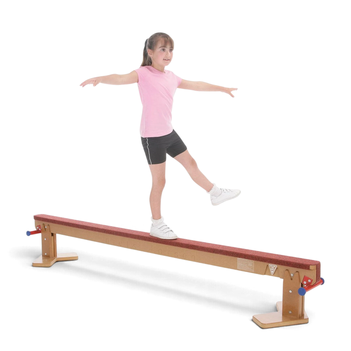Young girl practicing balance on a UK Gym Pits Eurobeam with a carpeted timber surface and adjustable height settings.