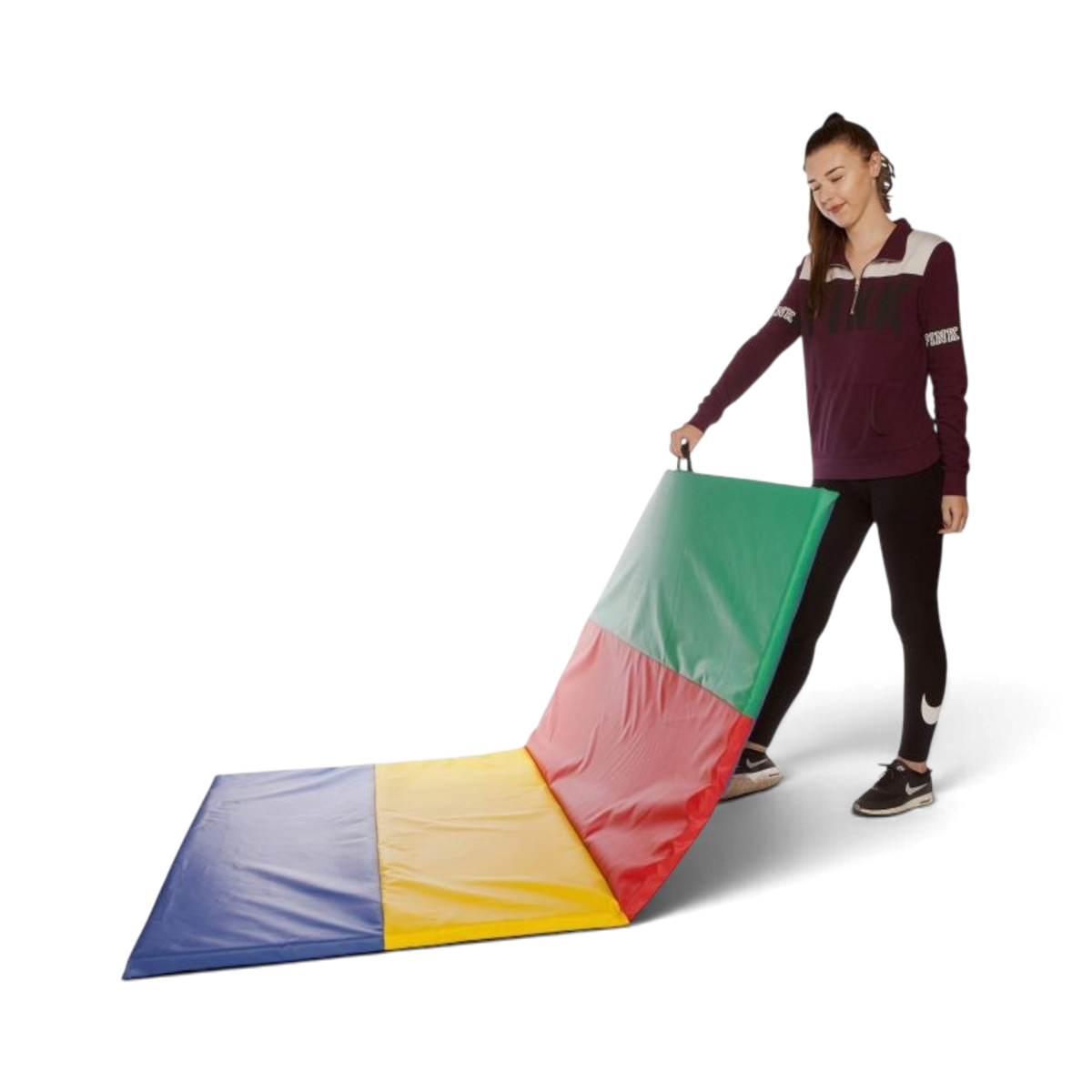 UK Gym Pits folding tumble mat with multi-coloured PVC panels and carry handle being folded by a young woman