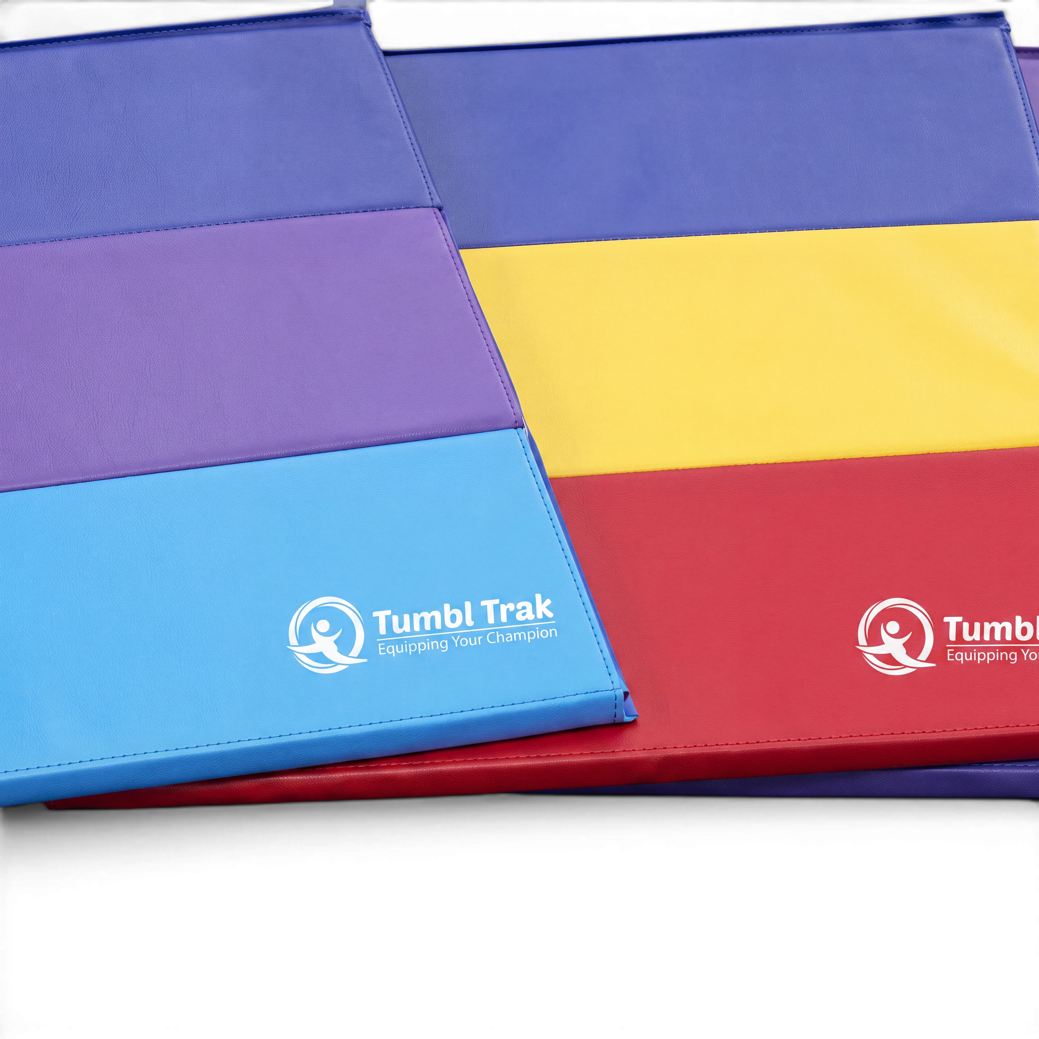 UK Gym Pits folding tumbling mats in vibrant blue, purple, yellow, and red vinyl for gymnastics training