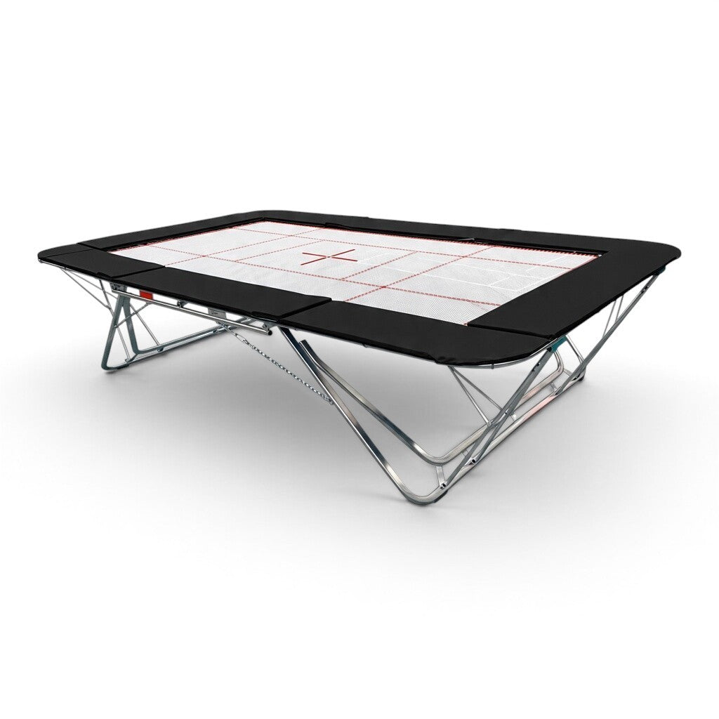 UK Gym Pits GMEX Extreme competition trampoline with a white web bed and black protective frame pads on a steel frame
