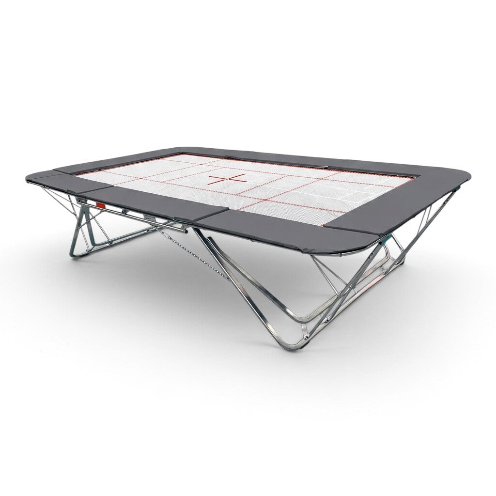 UK Gym Pits GMEX Extreme competition trampoline with a white web bed and grey protective frame pads on a white background