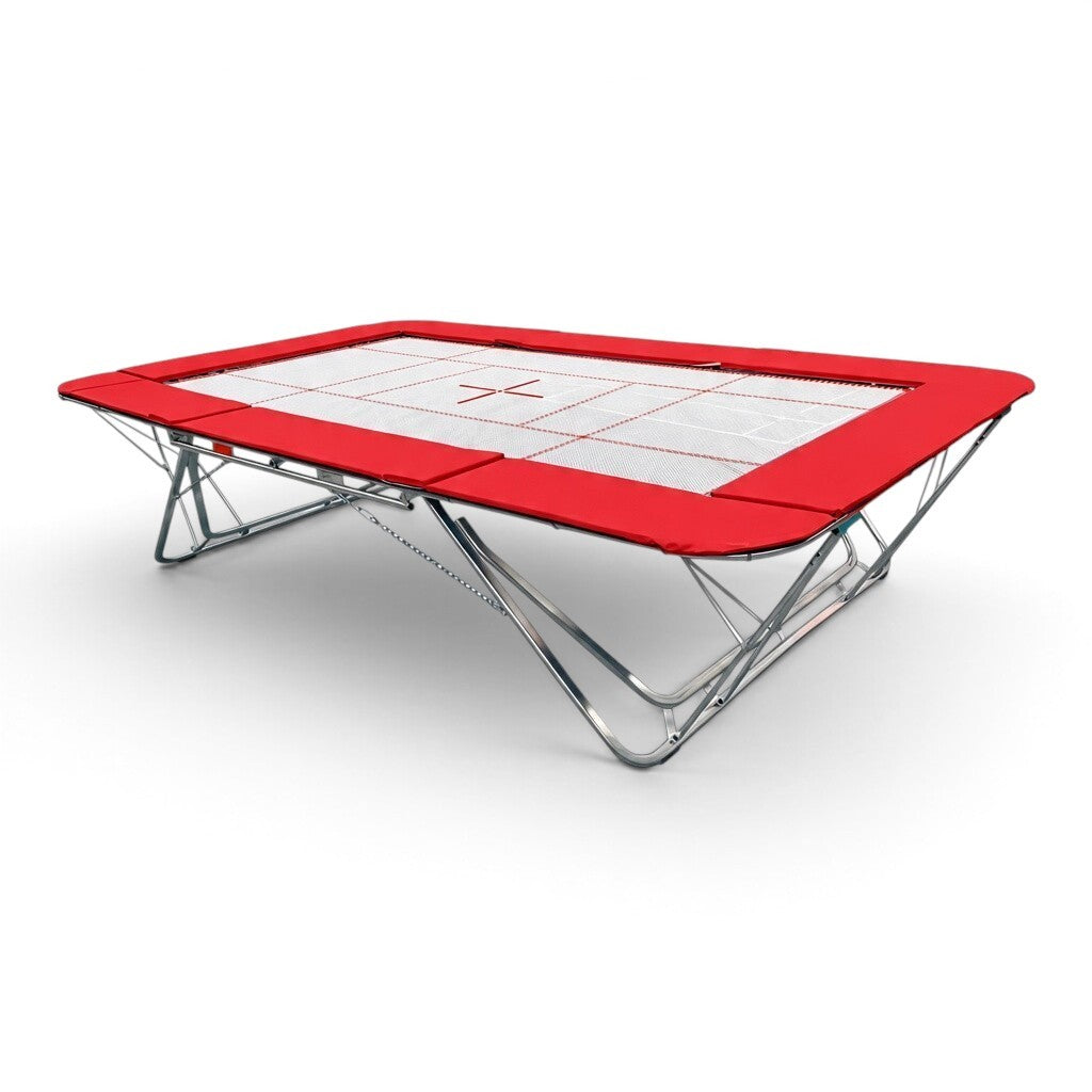 UK Gym Pits GMEX Extreme competition trampoline with a white web bed and red protective frame pads on a steel frame.
