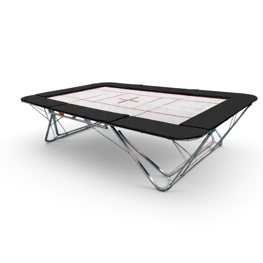 UK Gym Pits GMEX Extreme competition trampoline with a white web bed, black frame pads, and steel support frame.