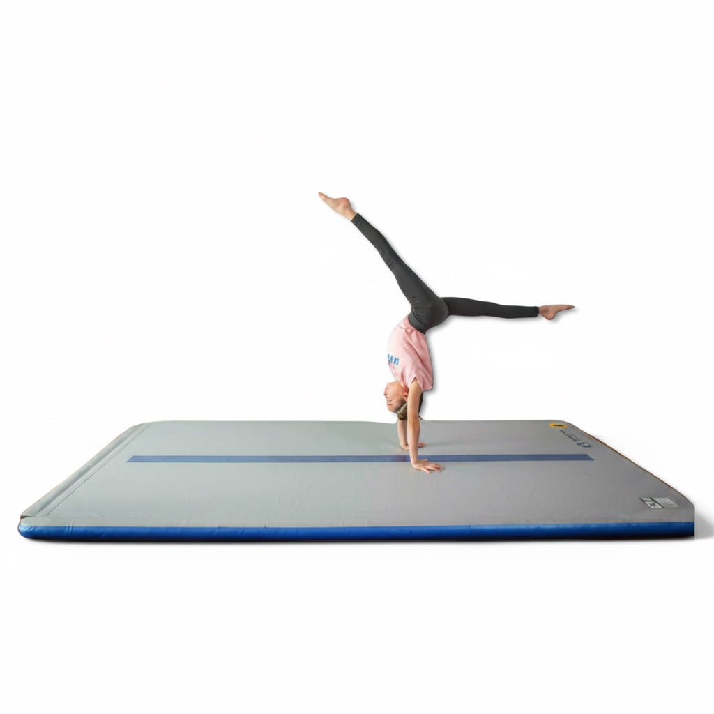 UK Gym Pits home air floor with a gymnast performing a handstand on the blue and grey inflatable training mat.