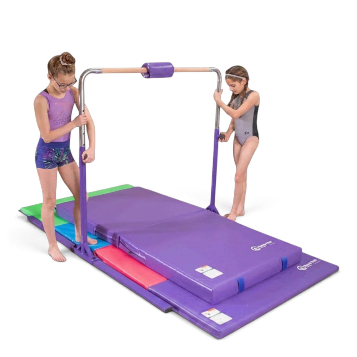 Two girls adjusting a purple UK Gym Pits home gymnastics kip bar with a solid maple wood rail and folding mat.