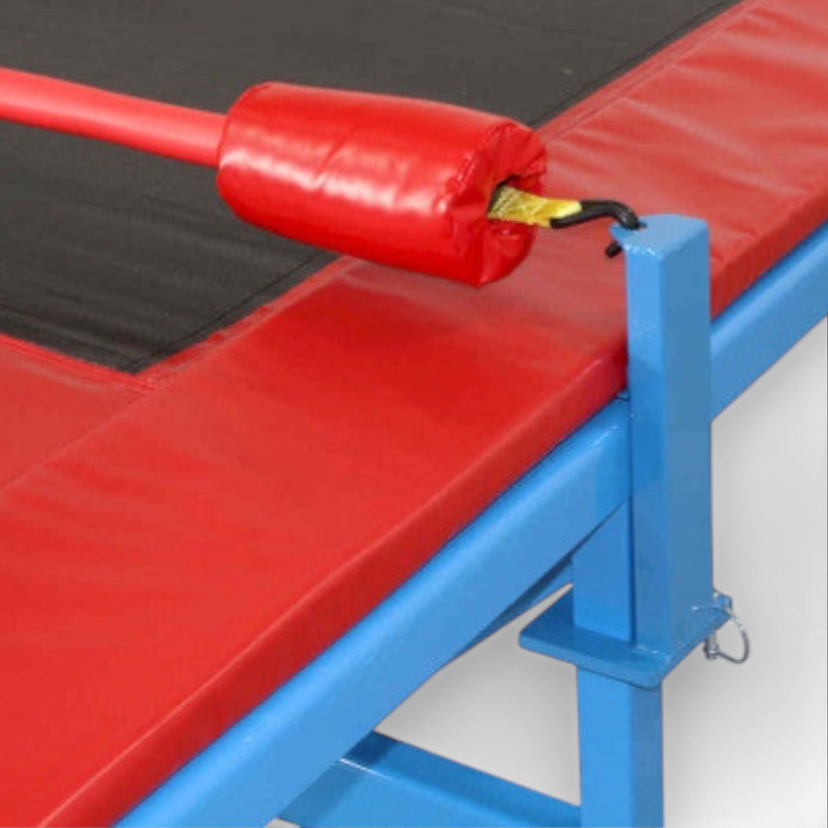UK Gym Pits Quick Flex bar with red foam padding and blue metal bracket attached to a gymnastics training track