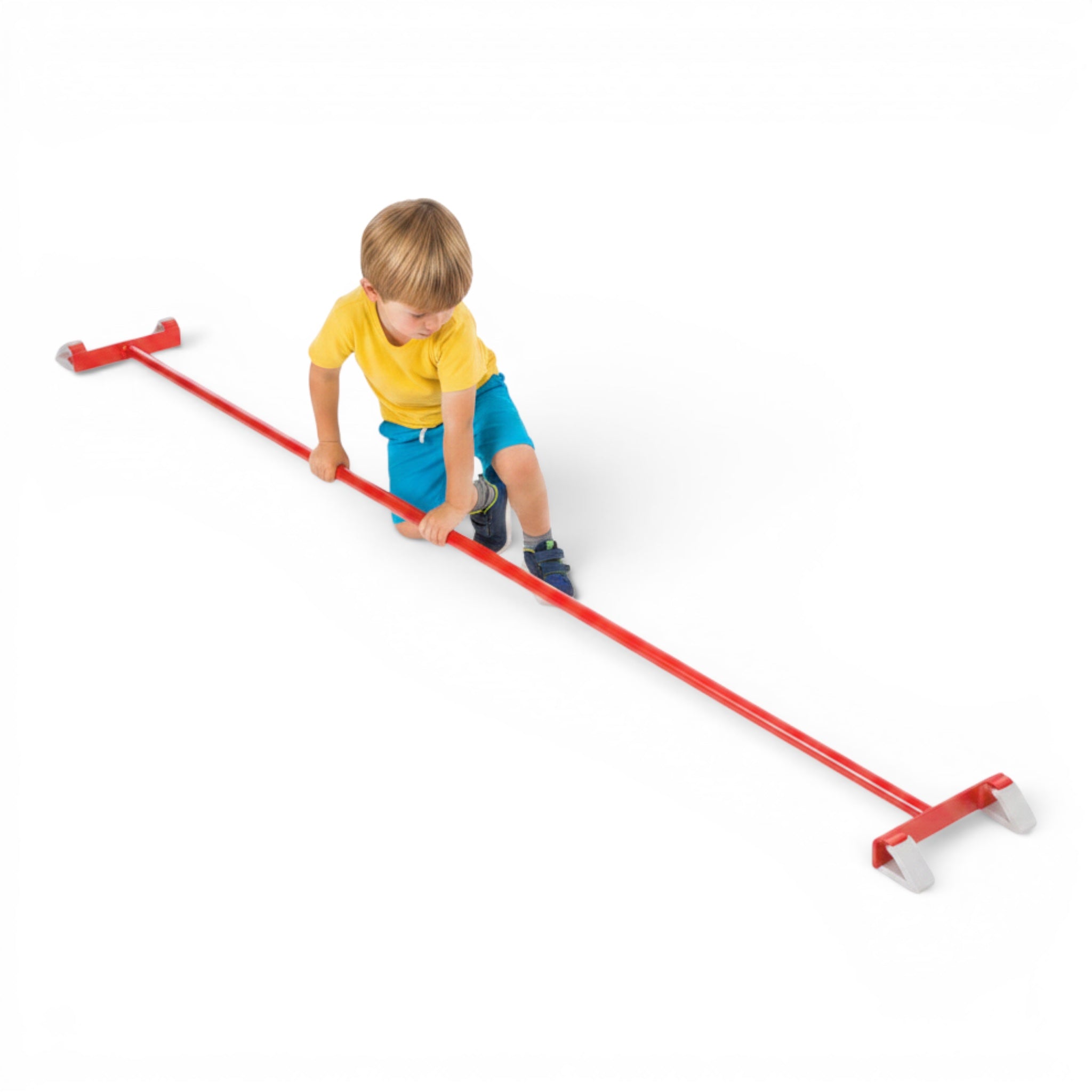 A young boy balancing on a red UK Gym Pits agility linking pole with safety hooks on a white background.