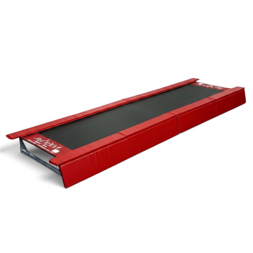 UK Gym Pits red padded vinyl safety skirts attached to the sides of a Tumbl Trak gymnastics training mat