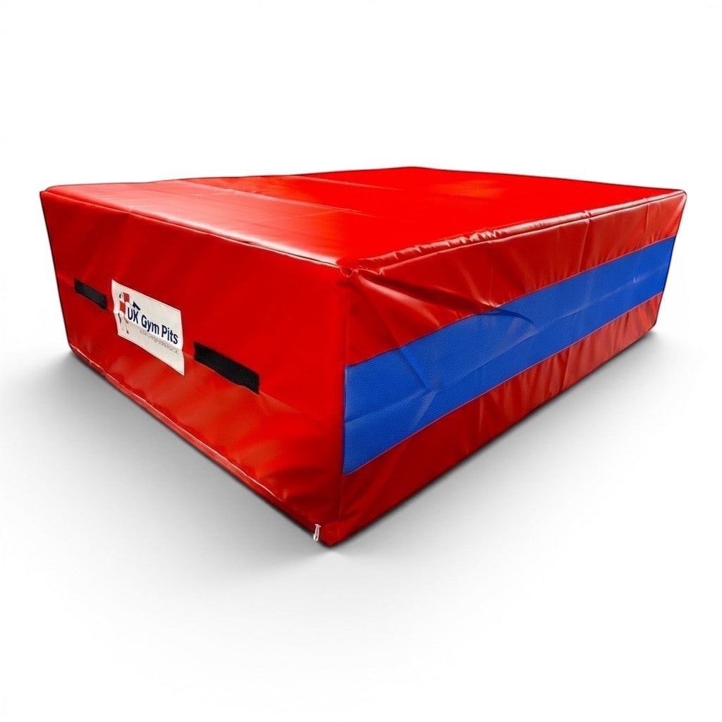 UK Gym Pits red and blue shock-absorbing resi foam landing pit with heavy-duty handles and anti-slip base.