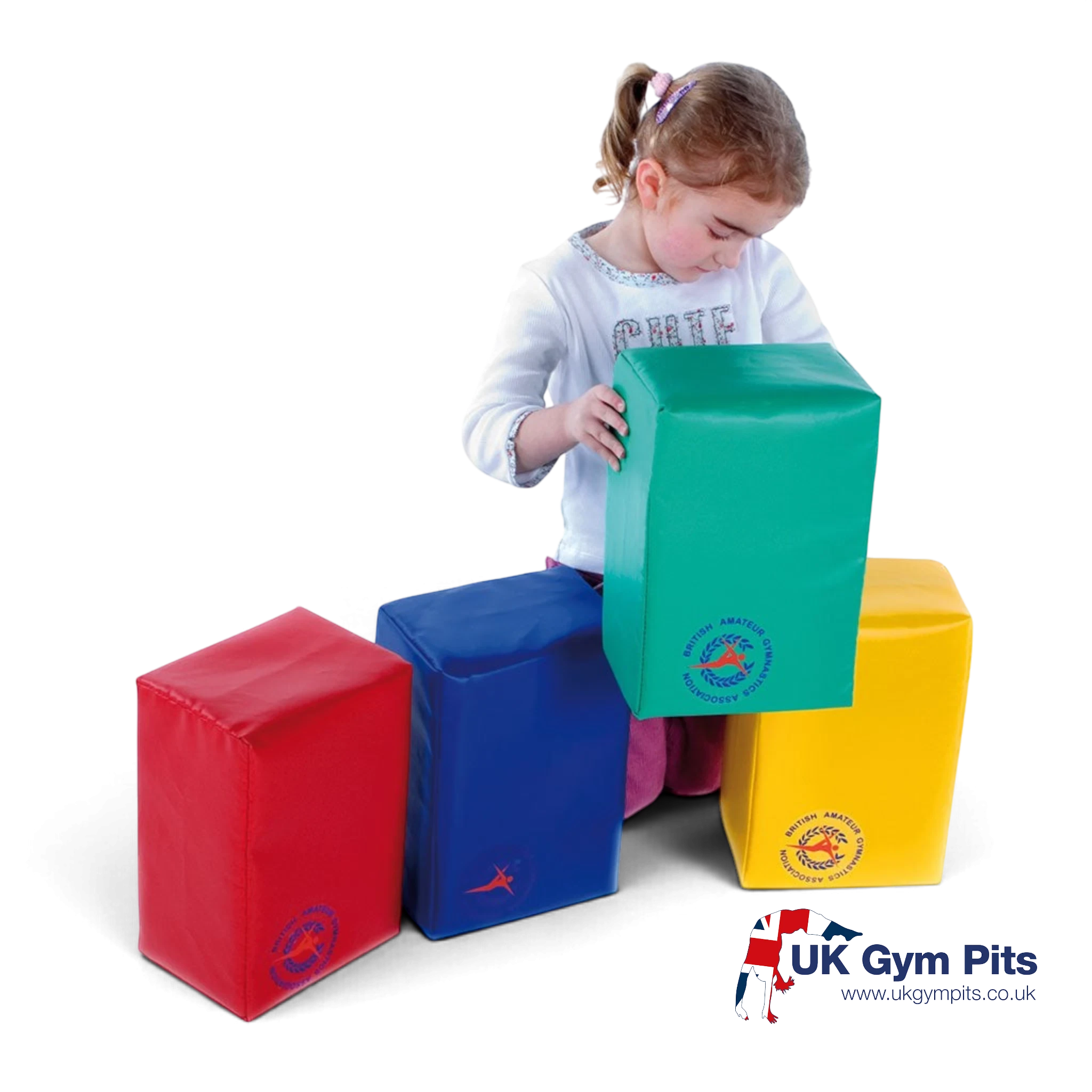 A young girl playing with UK Gym Pits Jump for Joy Frolic soft play bricks in red, blue, green, and yellow vinyl.