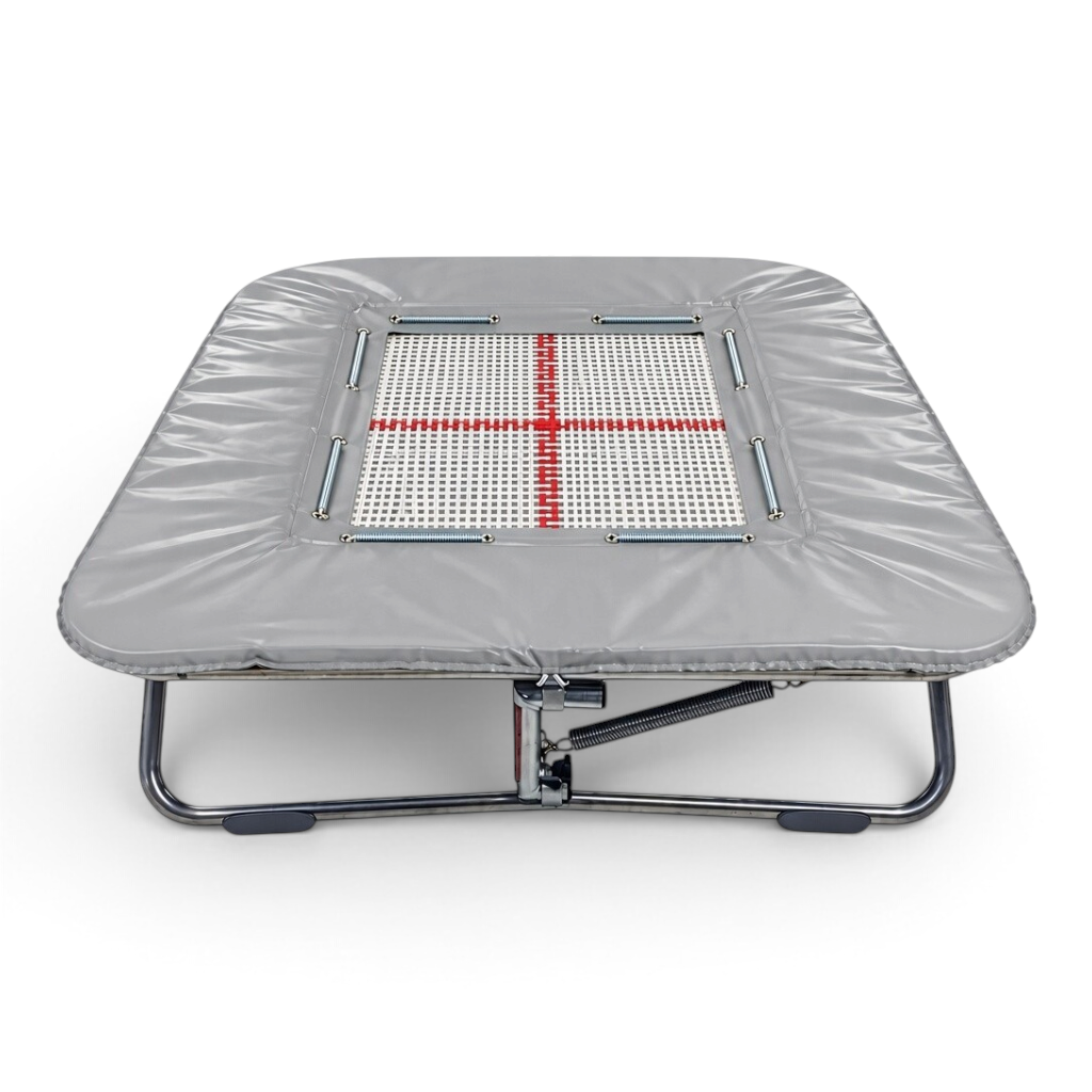 UK Gym Pits super mini trampoline with a white web bed, red cross marking, and grey protective frame pads.