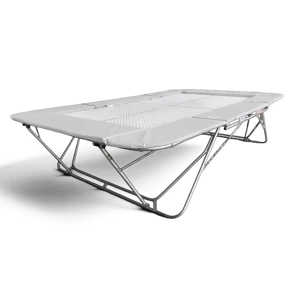 UK Gym Pits 77a standard competition trampoline with a white super-mesh bed and grey protective frame pads.