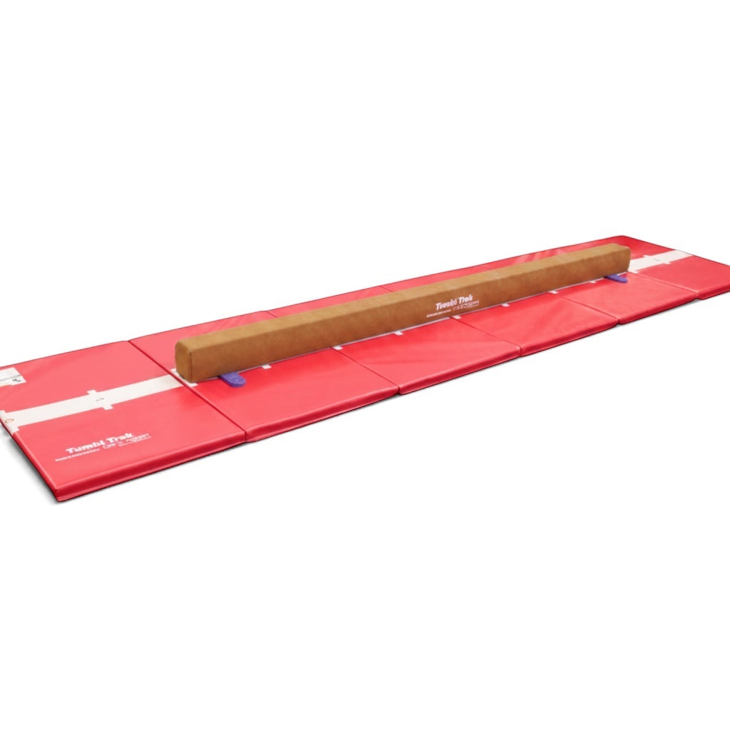 UK Gym Pits Addie beam with synthetic suede finish placed on a red foldable hopscotch tumbling mat for home training.