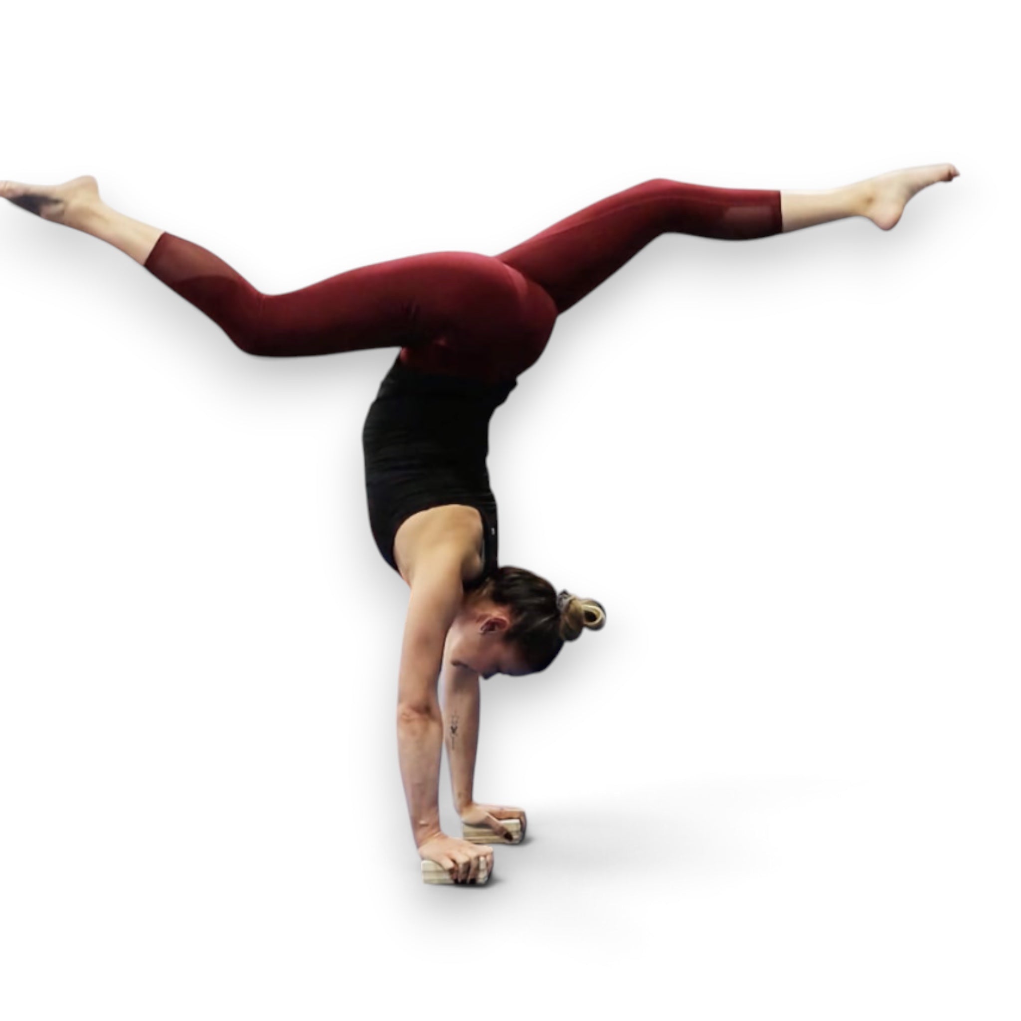 A gymnast performing a handstand on UK Gym Pits adjustable wooden handstand canes while wearing burgundy leggings.