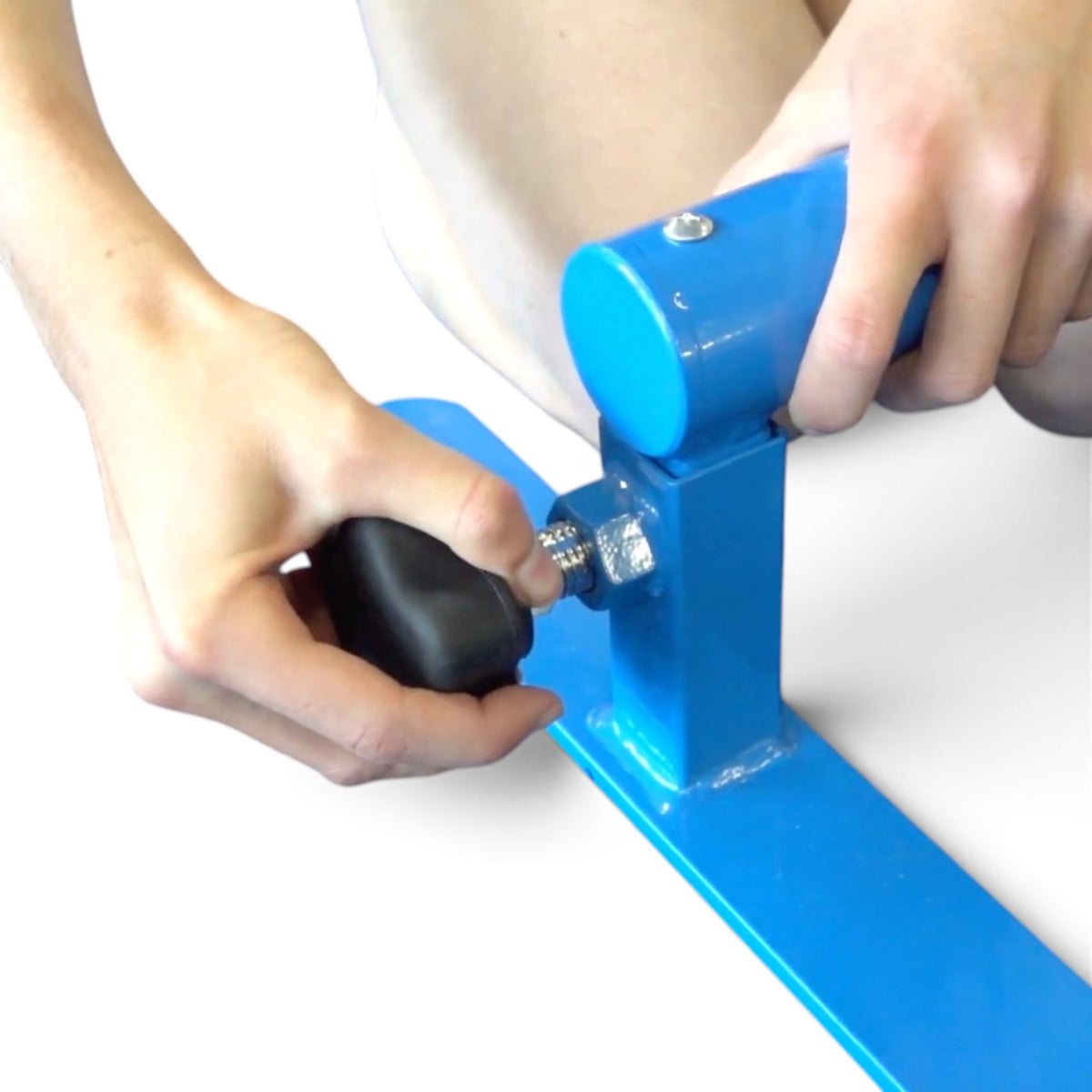 UK Gym Pits adjustable parallette bars showing a hand adjusting the height with the heavy duty spring loaded knob