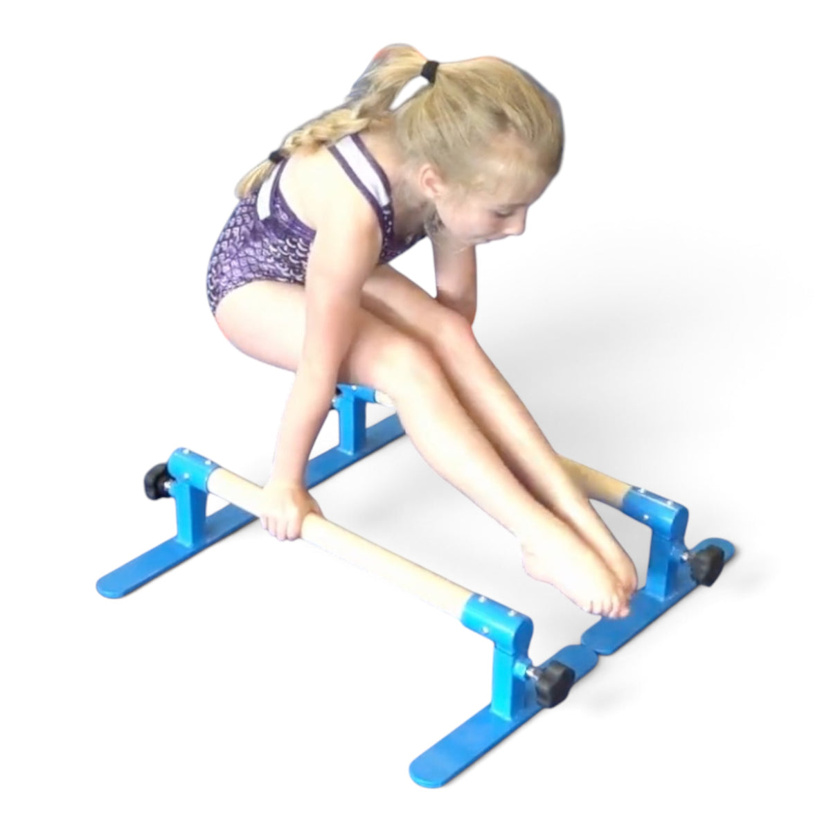 Young gymnast performing a pike hold on UK Gym Pits adjustable height parallette bars with blue steel frames