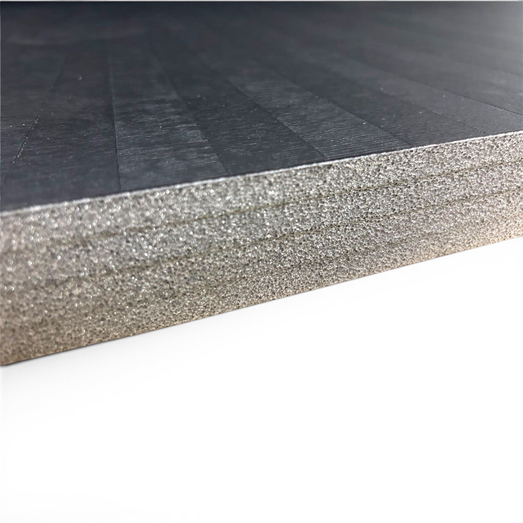 UK Gym Pits black hybrid mat roll showing the durable tatami PVC surface and high-density cross-linked XPE foam layer.