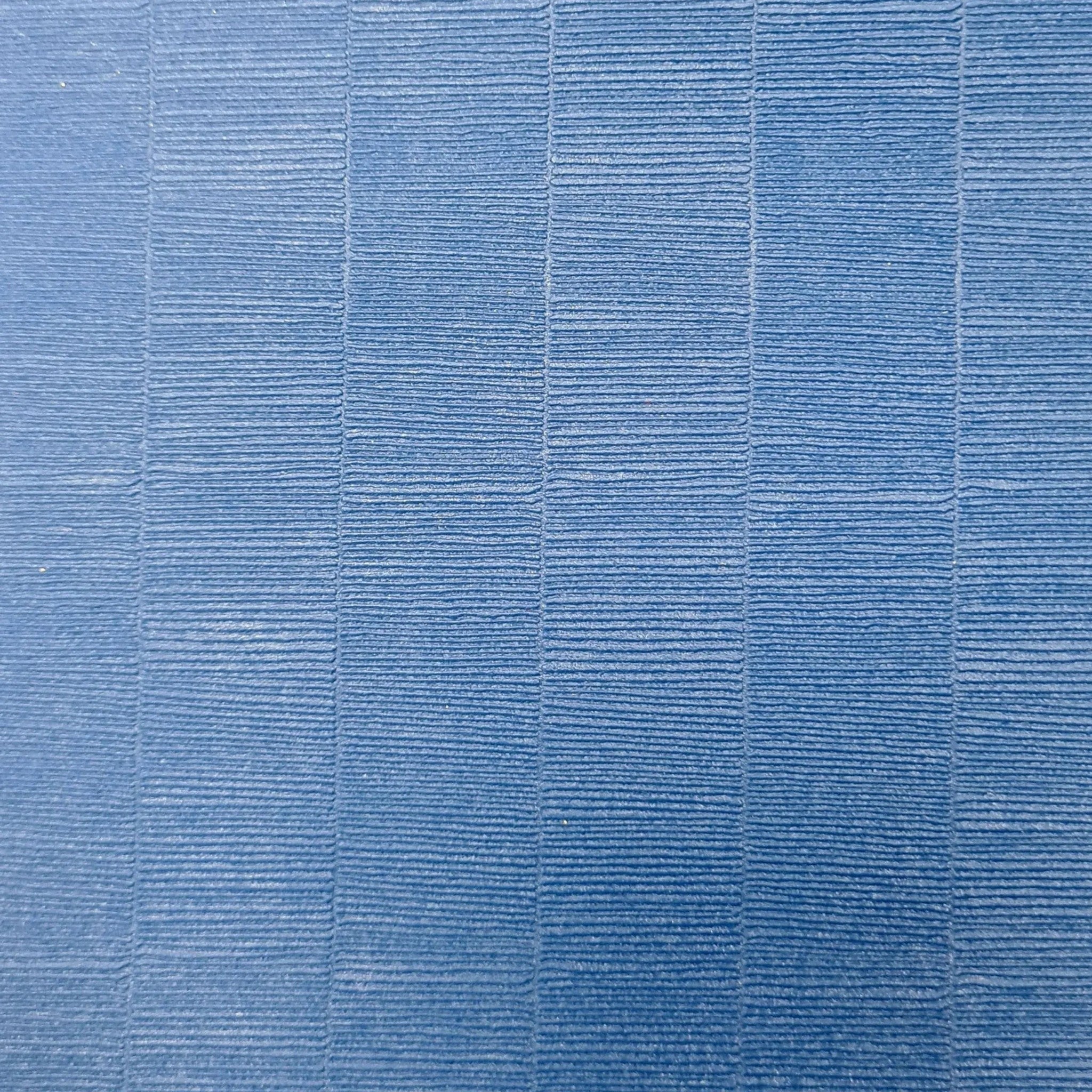 Close-up of the blue tatami-textured PVC surface of a UK Gym Pits Hybrid Connect gymnastics mat roll.