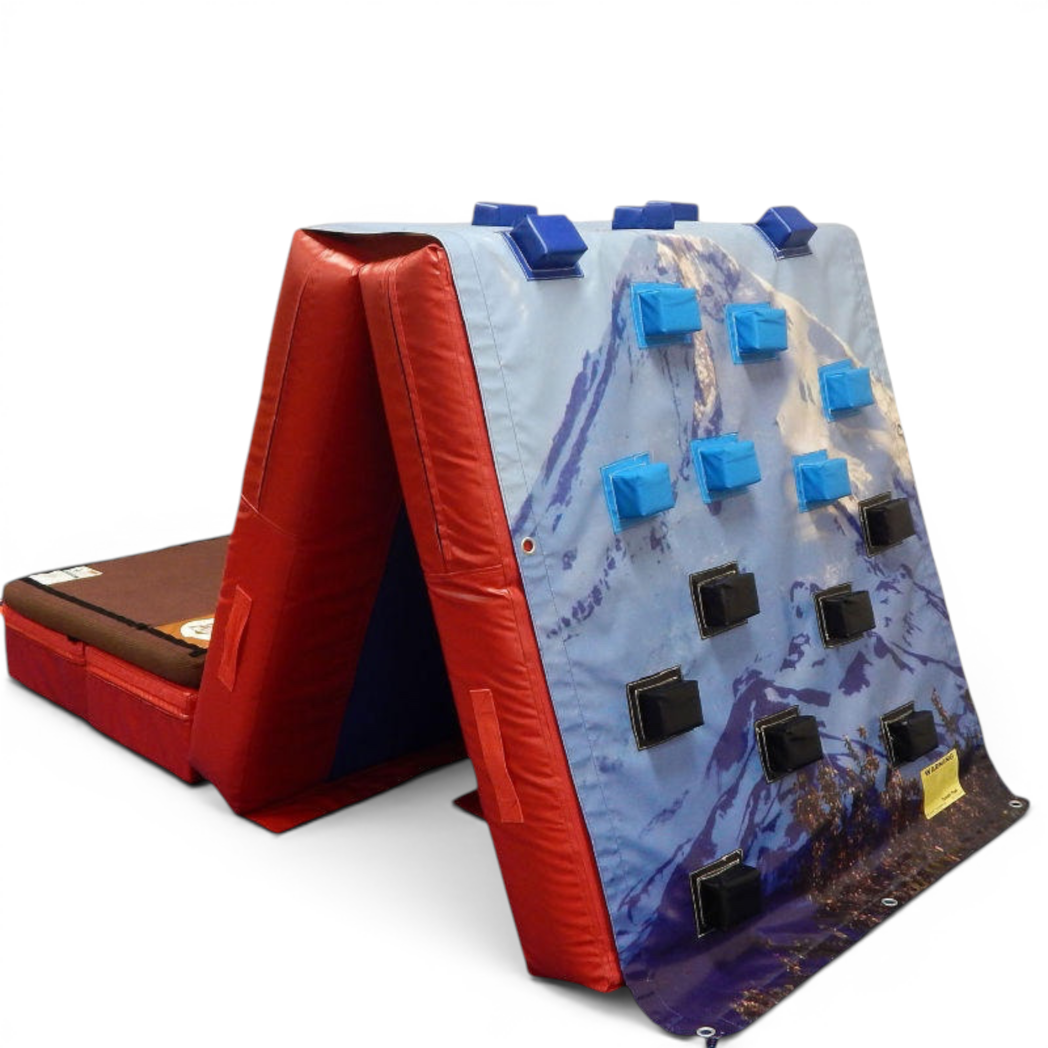 UK Gym Pits climbing wall overlay with blue and black foam holds on a mountain-printed vinyl mat for gym training.