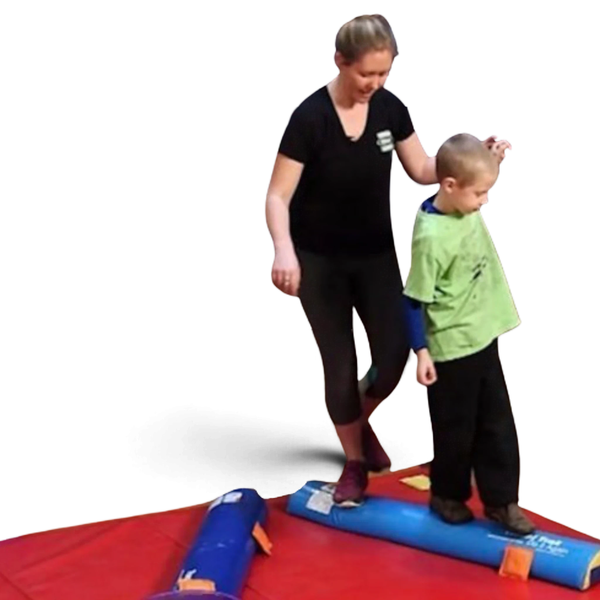 UK Gym Pits instructor assisting a child balancing on a blue foam half round training tool on a gym floor