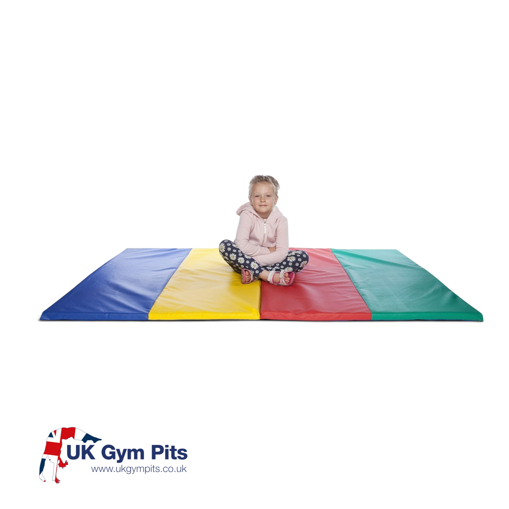 A young girl sitting on a UK Gym Pits folding tumble mat featuring blue, yellow, red, and green PVC panels.