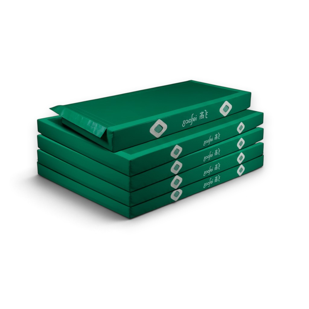 UK Gym Pits Gaofei green asymmetric bars landing mats stacked for gymnastics training and competition.
