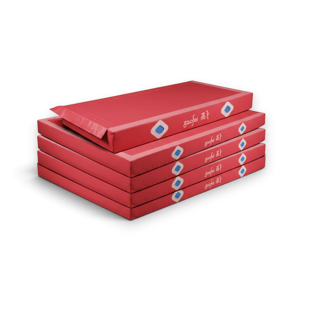 UK Gym Pits Gaofei red asymmetric bars landing mats stacked for gymnastics training and competition use.