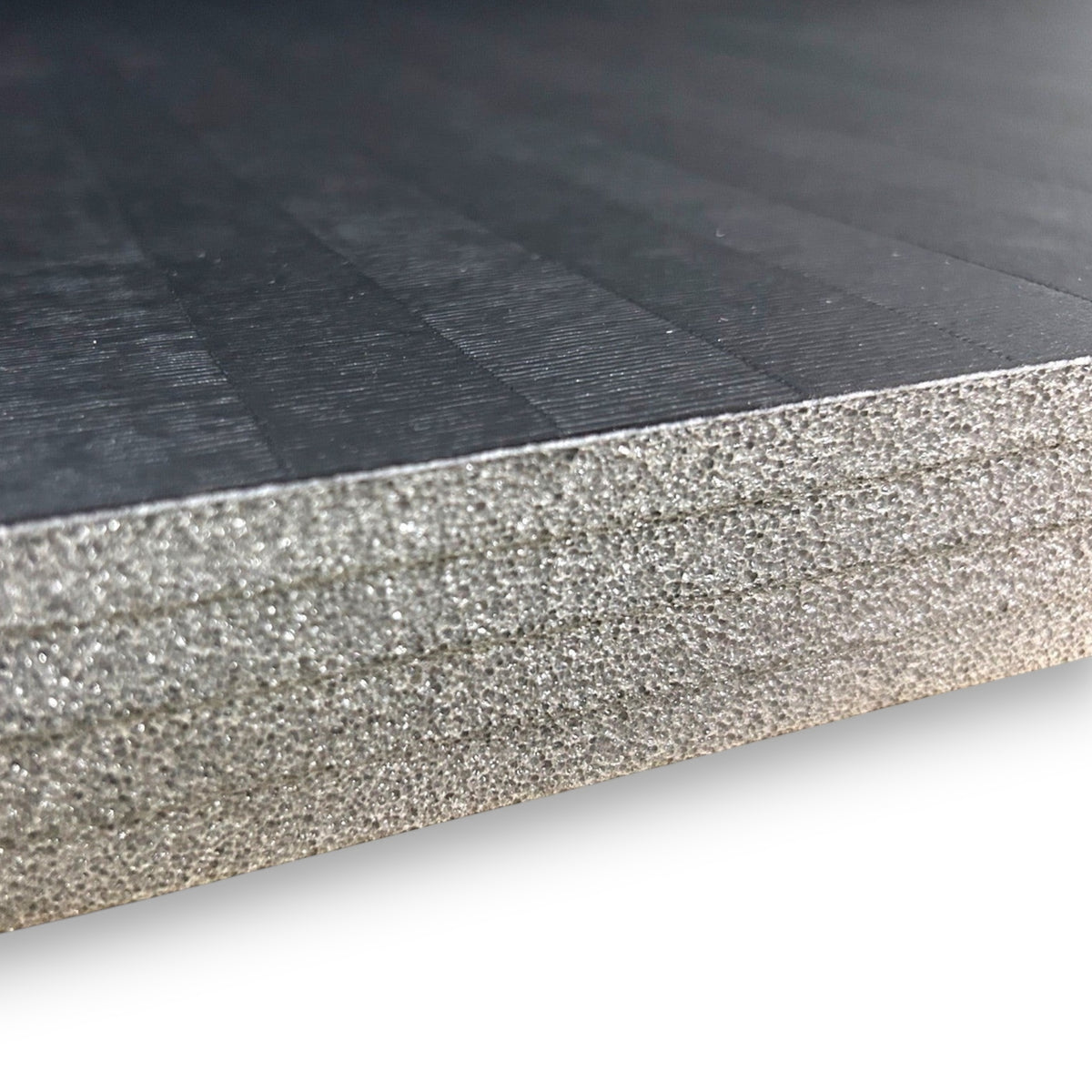 UK Gym Pits Hybrid Connect mat roll showing the durable black tatami-textured PVC surface and XPE foam core layer.
