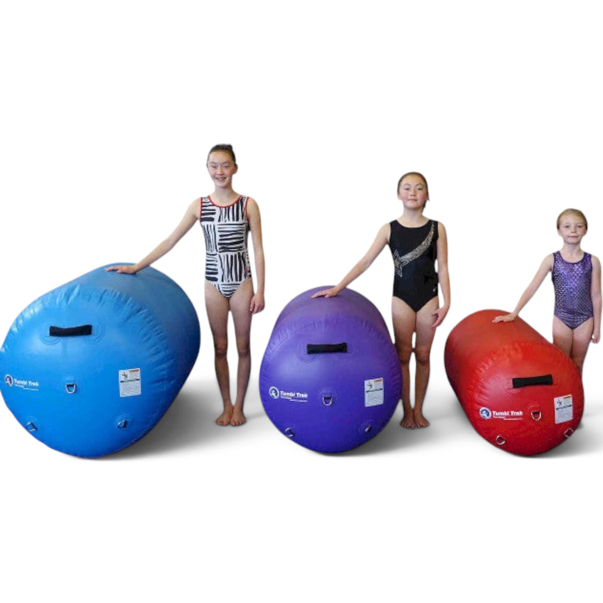 UK Gym Pits air barrels in blue, purple, and red with young gymnasts standing beside them for size comparison
