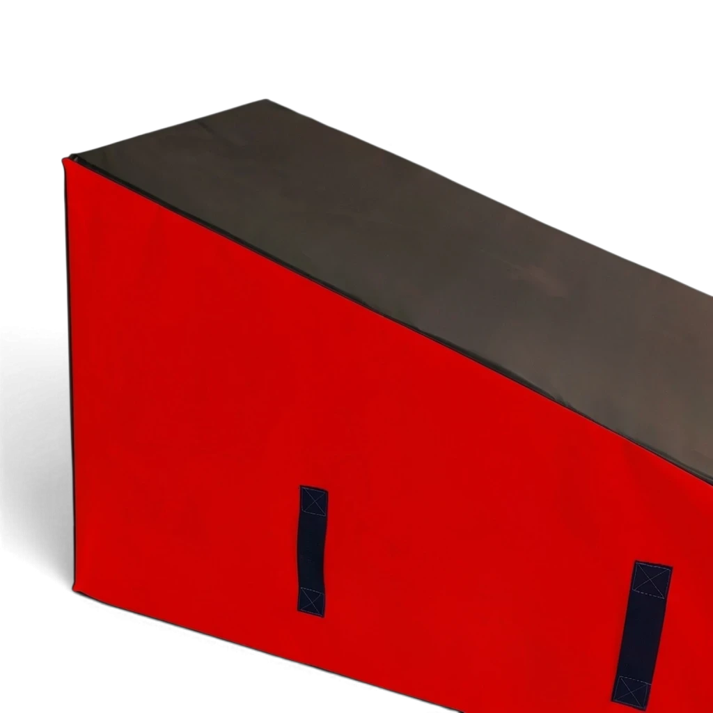 UK Gym Pits parkour wedge block with black top and red sides, featuring carry handles for freestyle gymnastics training.