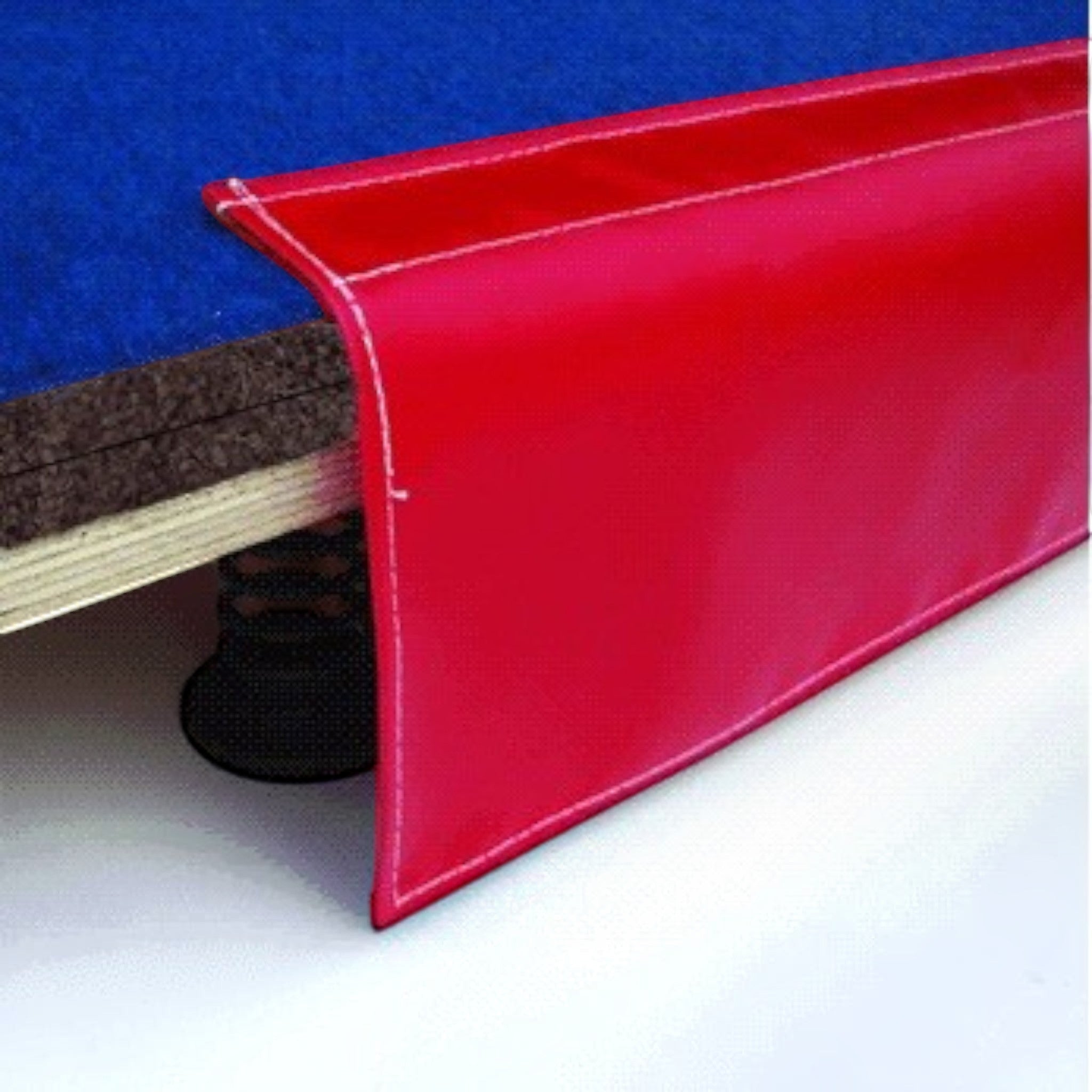 UK Gym Pits red PVC drop-down side skirt attached to a blue carpeted sprung gymnastics floor with Velcro