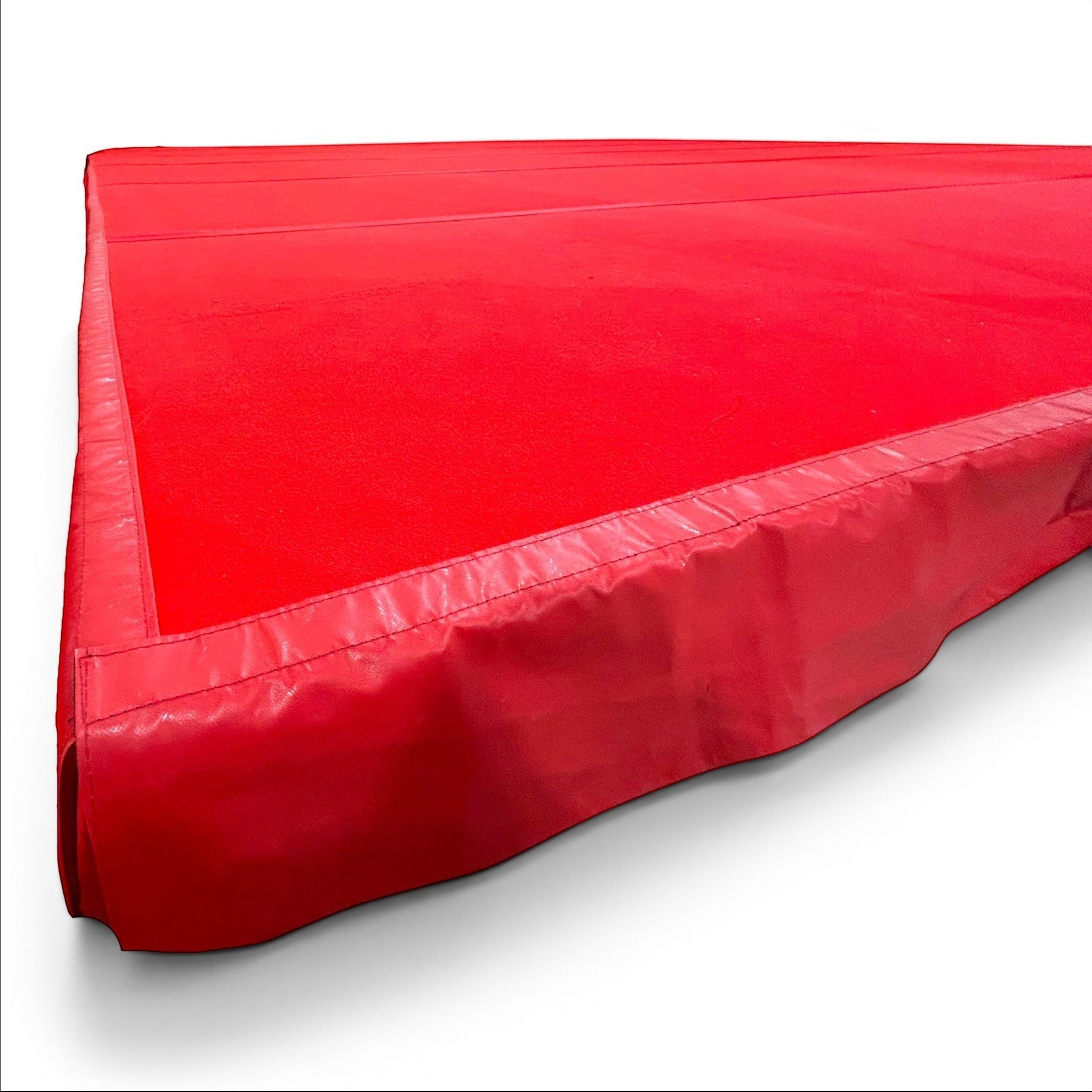 UK Gym Pits red PVC side skirt attached to a gymnastics sprung floor with Velcro overflap for safety and aesthetics.