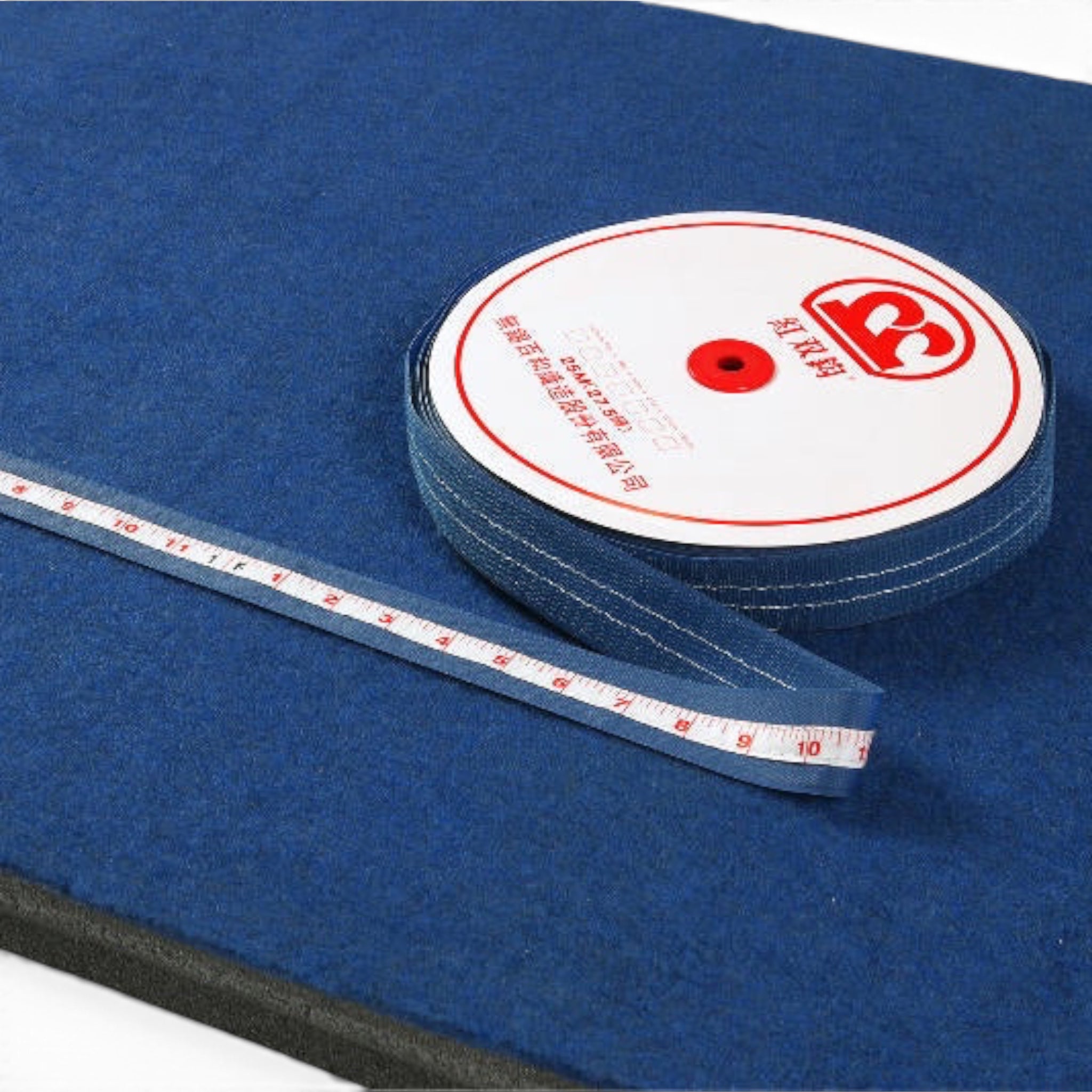 UK Gym Pits runway tape measure with Velcro backing on a blue carpeted surface for gymnastics training
