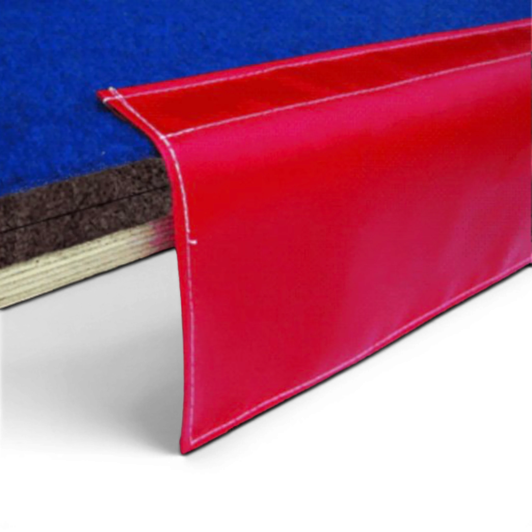 UK Gym Pits gymnastics sprung floor edge with blue carpet surface, plywood base, and protective red PVC side skirt
