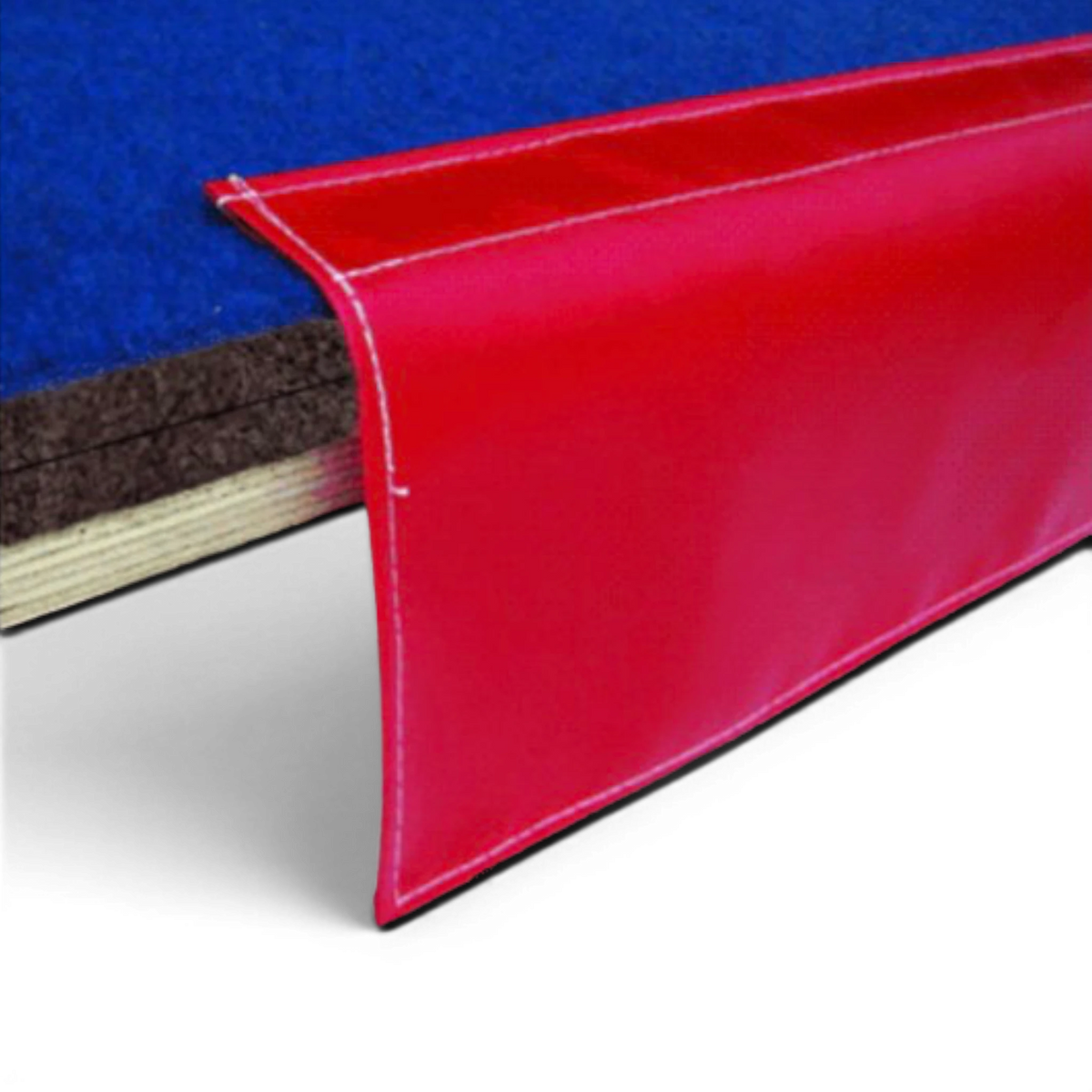 UK Gym Pits cheerleading sprung floor edge with blue carpet surface, plywood base, and red protective side skirt.