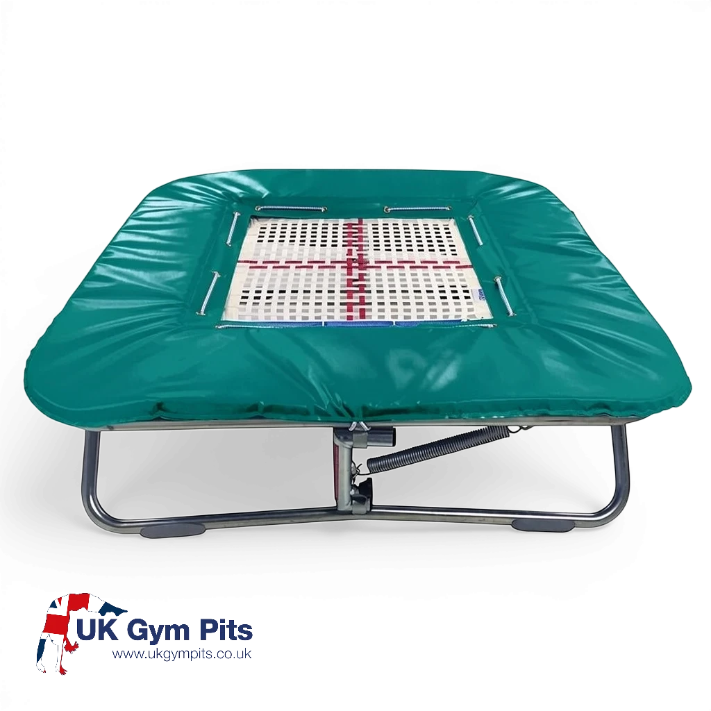UK Gym Pits super mini trampoline with a web bed and green protective frame pads on a black background.