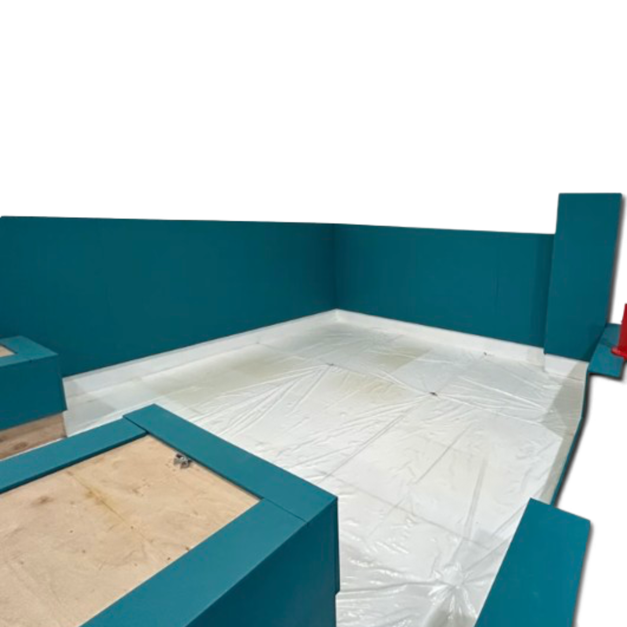 UK Gym Pits teal foam wall and edge padding installed around a gymnastics landing pit with a white base.