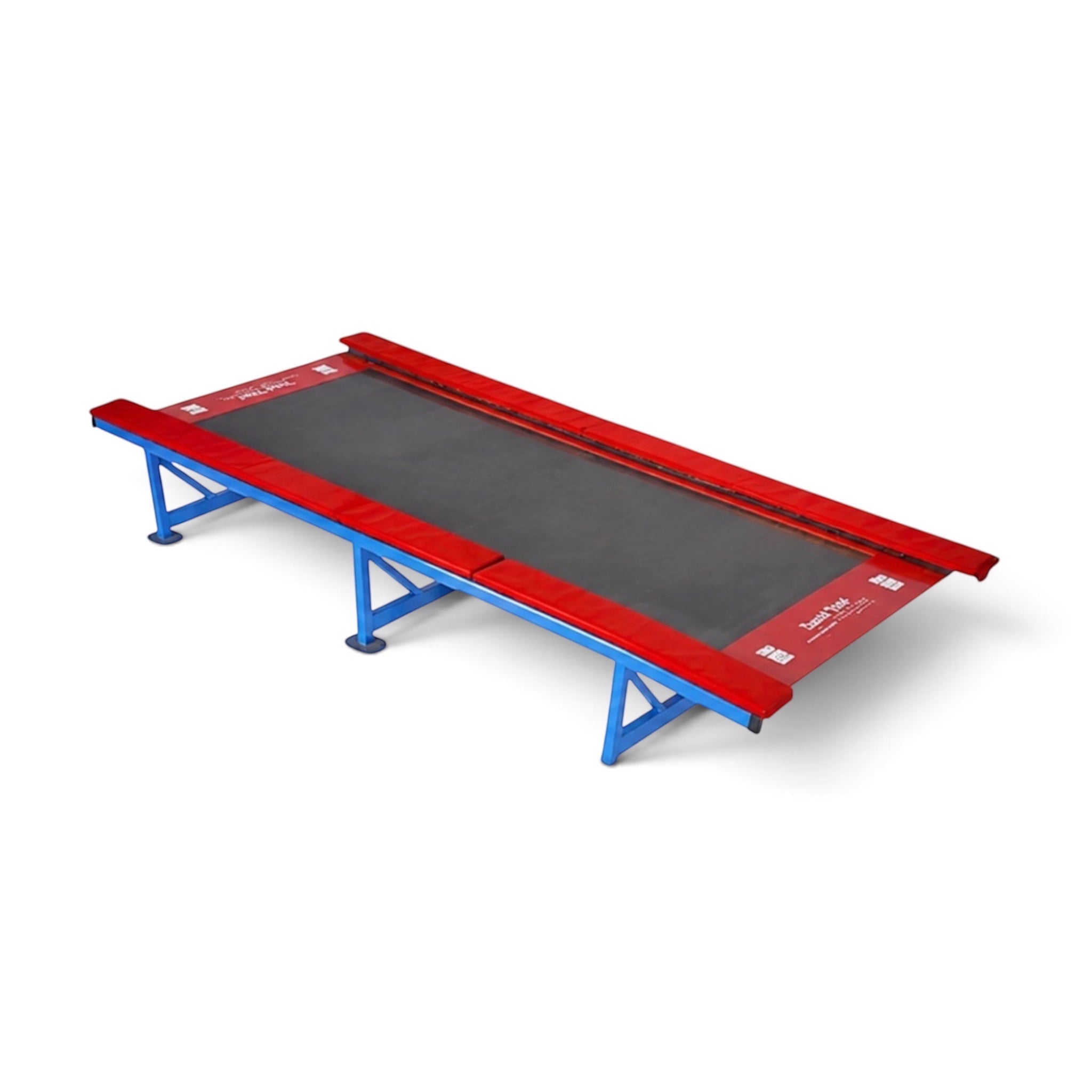 UK Gym Pits Tumbl Trak gymnastics training equipment with a royal blue steel frame, black bed, and red safety pads.