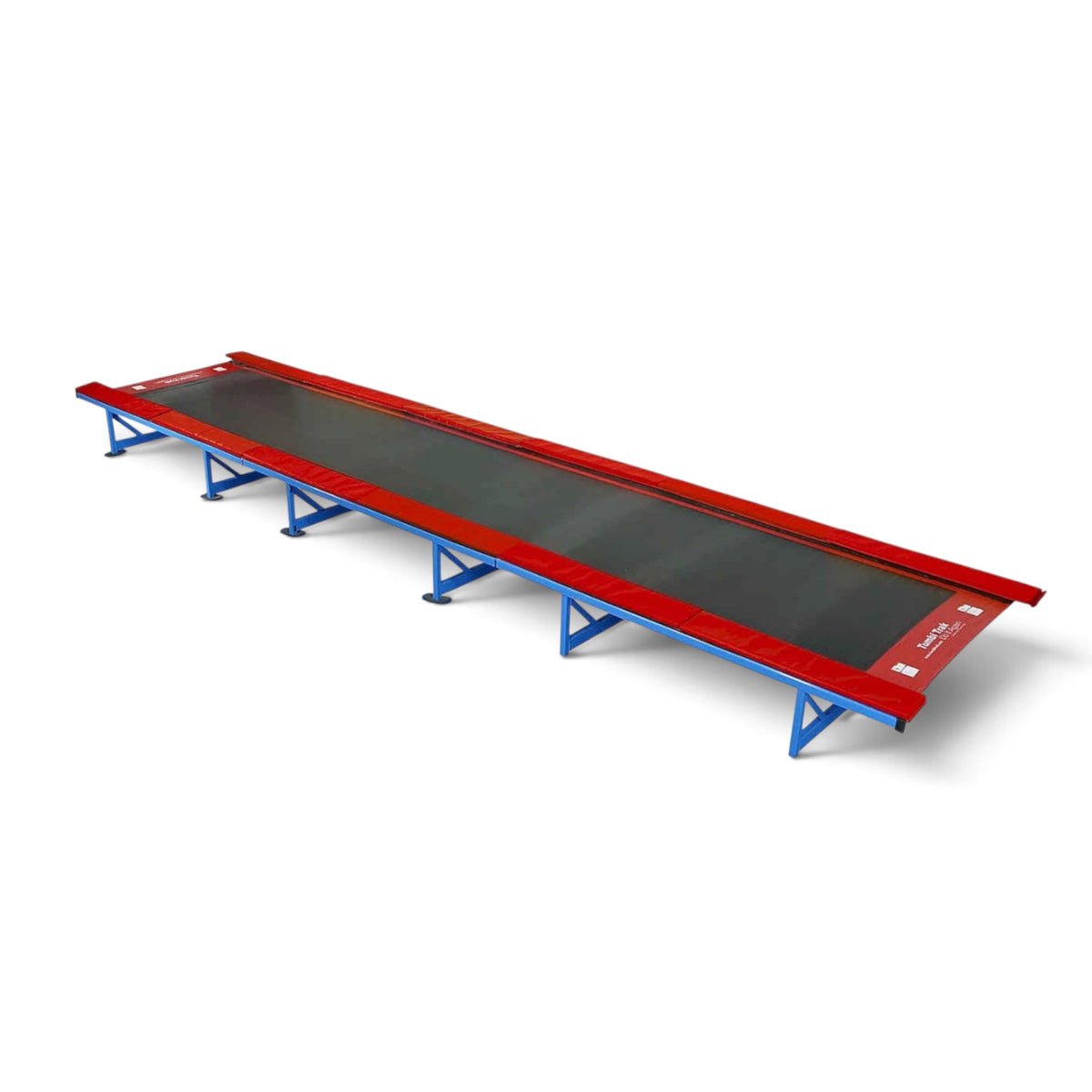 UK Gym Pits Tumbl Trak gymnastics training track with royal blue steel frame, black bed, and red safety pads.